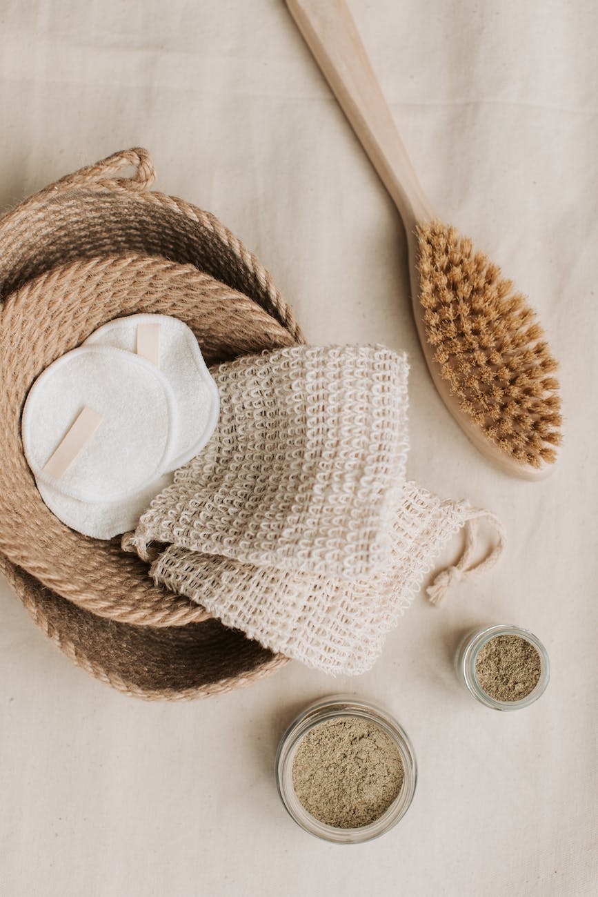 hemp washcloth and cotton pads in braided jute basket beside wooden brush