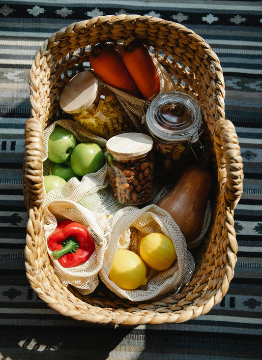 wicker basket with vegetables and products placed on table in sunny day