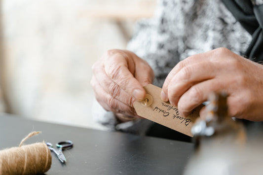 person putting jute rope on a tag